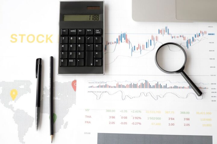 Máy tính cầm tay và kính lúp đặt trên bảng số liệu